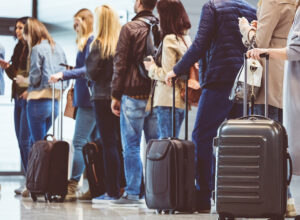 People lining up with carry-on baggage to board a flight