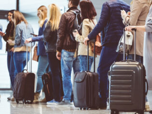 People lining up with carry-on baggage to board a flight