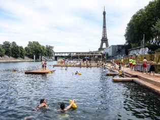 People swimming in the River Seine with a view of the Eiffel Tower