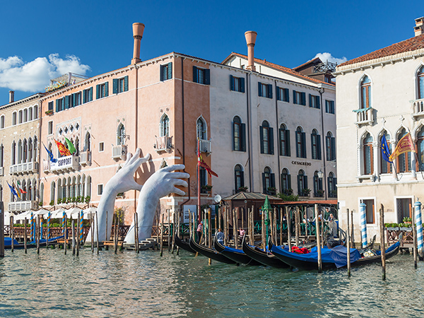 The Limelight Arts Travel 2026 Tour Program includes seeing the Monumental big hands in Venice that highlights climate change with blue sky