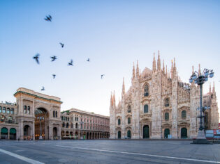 Galleeria Vittorio Emenuele and Milan Cathedral square with flying pegion in the morning