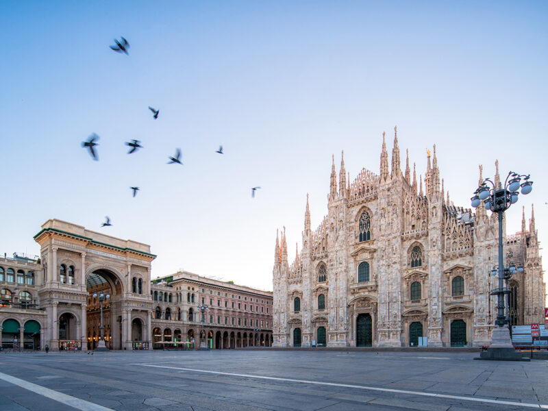 Galleeria Vittorio Emenuele and Milan Cathedral square with flying pegion in the morning