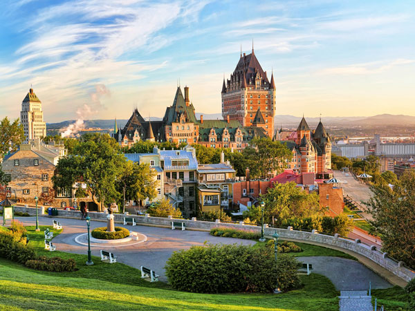 Panoramic view of Chateau Frontenac surrounded by greenery in Old Quebec, Canada at sunrise