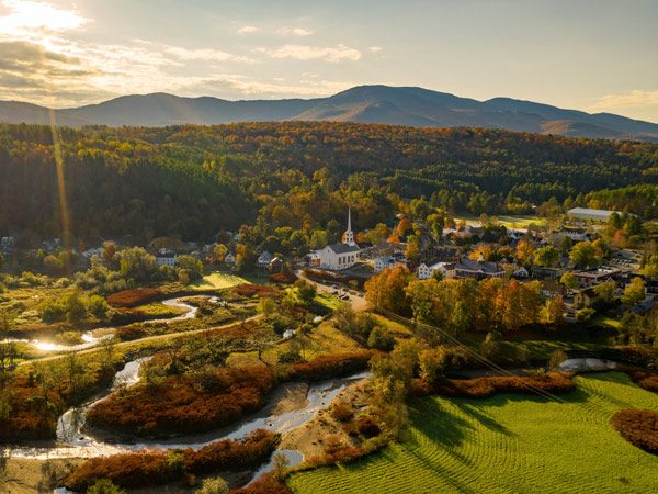 Aerial view of charming small town Stowe in Vermont. Mountains with fall multicolor trees
