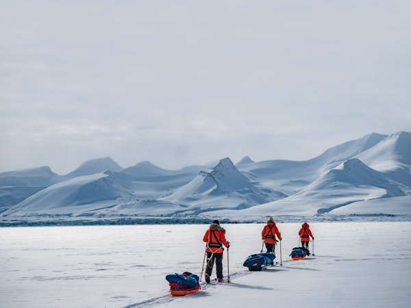 three people walking on ice in Svalbard