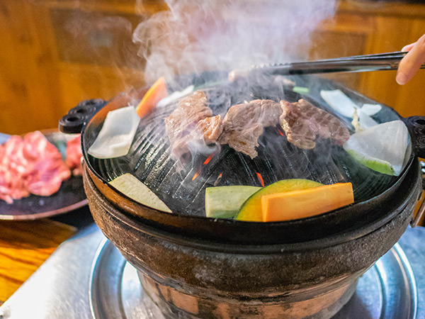 person cooking Genghis Khan barbecue in hokkaido japan