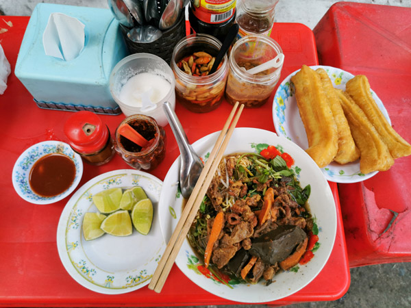 Cambodian yellow noodle soup with pork and pig blood