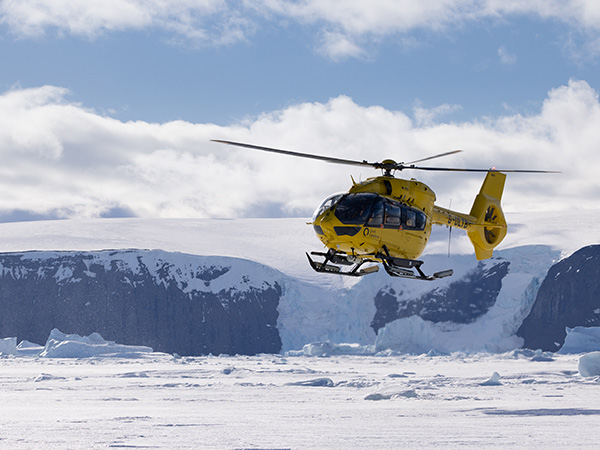 helicopter flying over antarctica