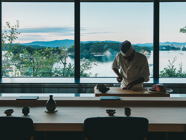A chef prepares sushi with the mountains and sea as a backdrop — a moment to get beautifully lost in Japan’s flavours and scenery.