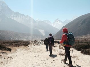 group tour hiking towards himalayan mountain ranges