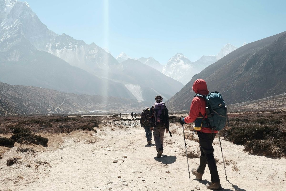 group tour hiking towards himalayan mountain ranges