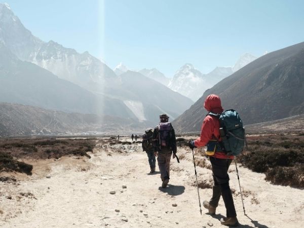 group tour hiking towards himalayan mountain ranges