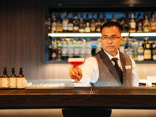A bartender serving a drink at The Explorer Lounge & Bar.