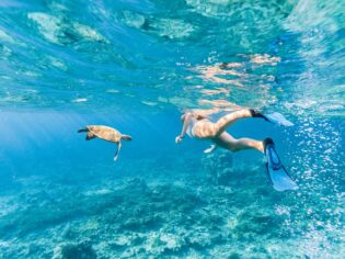 Woman explores the reef around the atoll in the Maldives