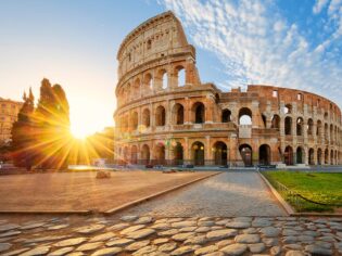 in front of the the Colloseum in rome at sunset
