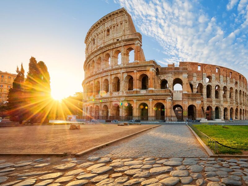 in front of the the Colloseum in rome at sunset