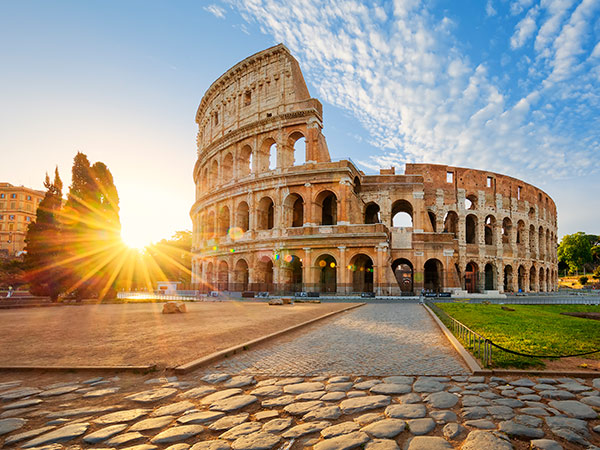 in front of the the Colloseum in rome at sunset