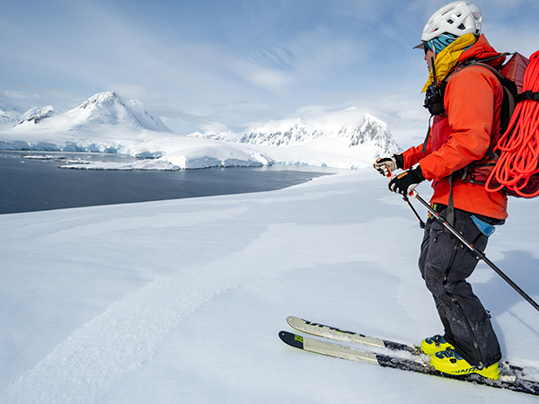 traveller skiing in antarctica with aurora