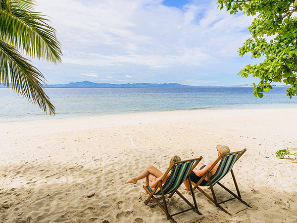 a couple on beach chairs at Malamar Beach Club fiji