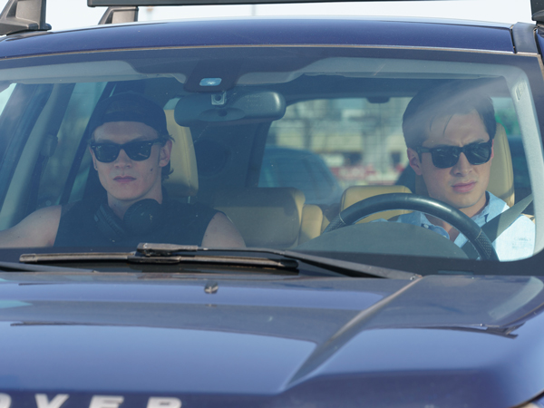 Connor Storrie and Hudson Williams as Ilya Rozanov and Shane Hollander in Heated Rivalry in car on their way to the cottage