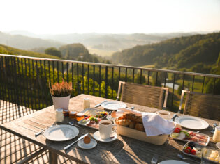 A traditional Austrian meal, beautifully presented on a table with breathtaking views beyond.