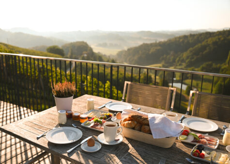 A traditional Austrian meal, beautifully presented on a table with breathtaking views beyond.