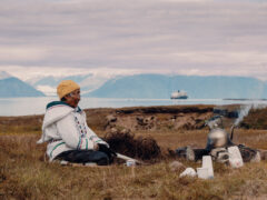Local woman sits in the grasslands of Gjoa Haven / Uqsuqtuuq