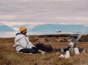 Local woman sits in the grasslands of Gjoa Haven / Uqsuqtuuq