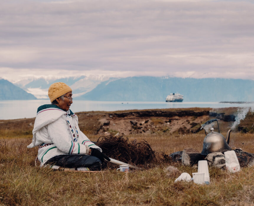 Local woman sits in the grasslands of Gjoa Haven / Uqsuqtuuq
