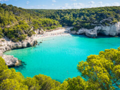 Cala Mitjana beach in Menorca .