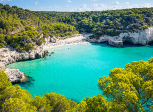 Cala Mitjana beach in Menorca .