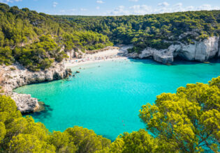 Cala Mitjana beach in Menorca .