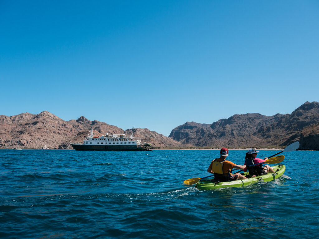 Guests kayaking nearby uncruise adventure ship