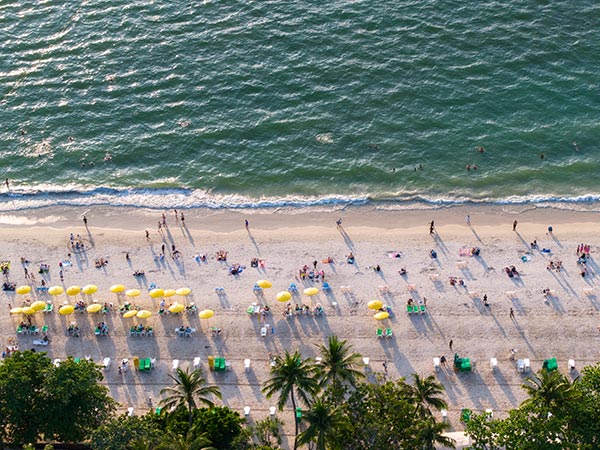 Aerial top-down view of Patong Beach with tourists, umbrellas