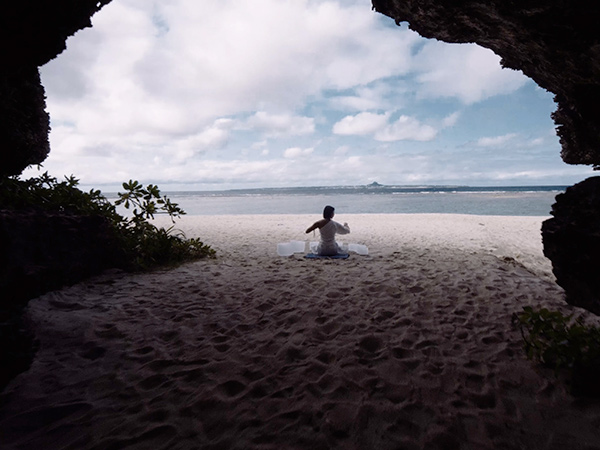 woman sitting on beach on seseko island
